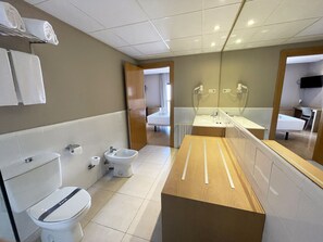 Un baño moderno con inodoro, bidé y lavamanos.