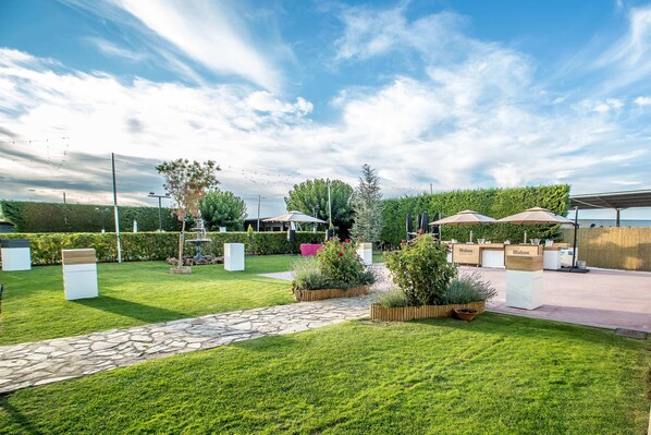 A well-maintained outdoor area with a stone pathway, neatly trimmed grass, and various planters.