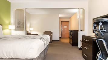 A hotel room with a bed, a desk, a chair, and a dresser.