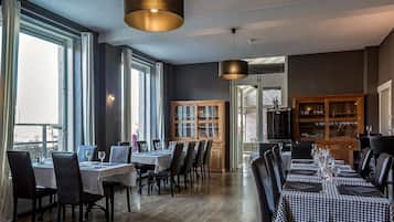 A restaurant with checkered tablecloths, wooden cabinets, and pendant lighting.