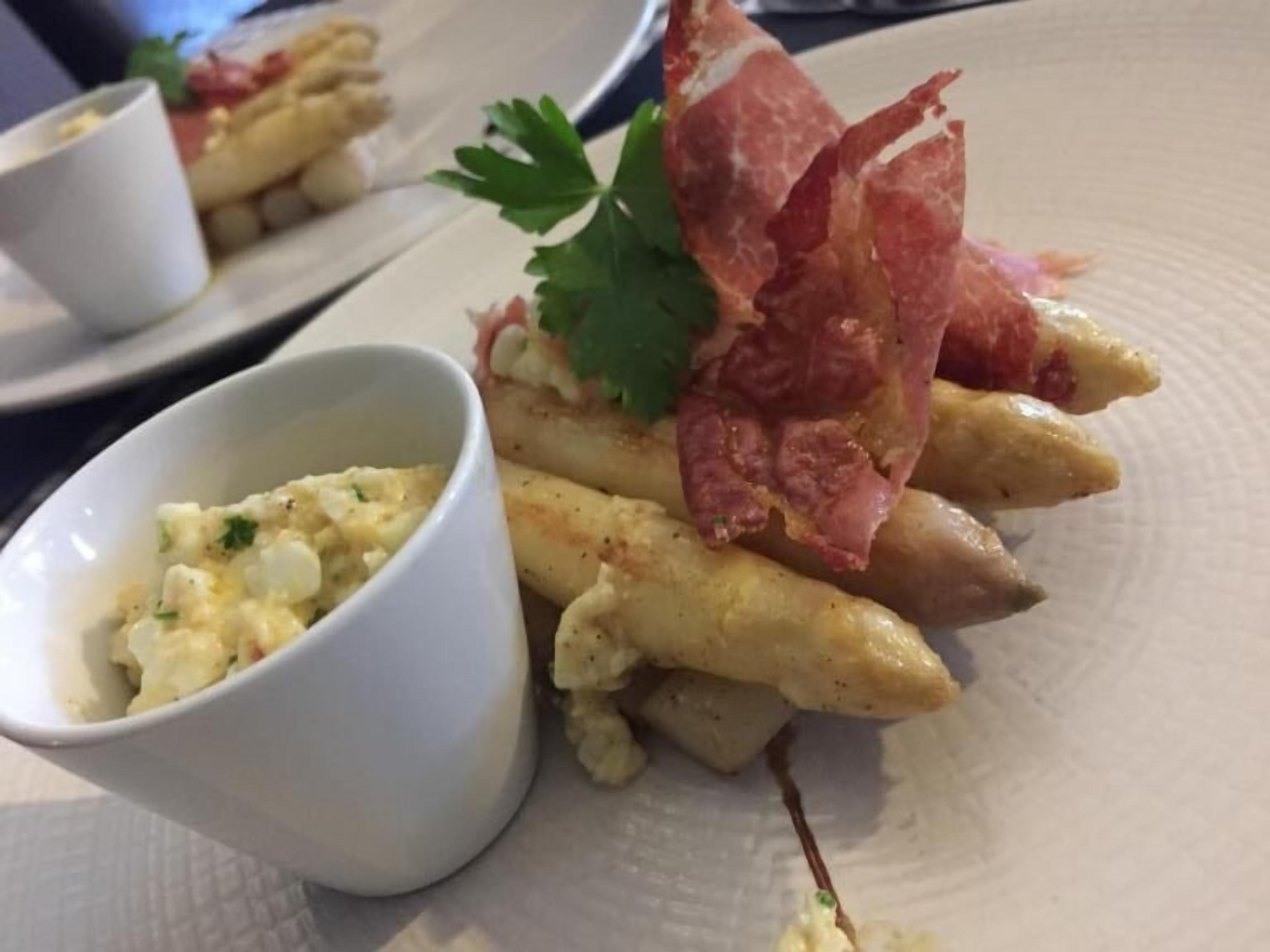 Une assiette de nourriture comprenant des frites, un morceau de viande et un petit bol de sauce.