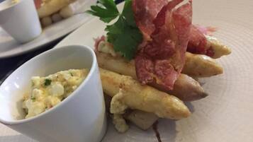 Une assiette de nourriture comprenant des frites, un morceau de viande et un petit bol de sauce.