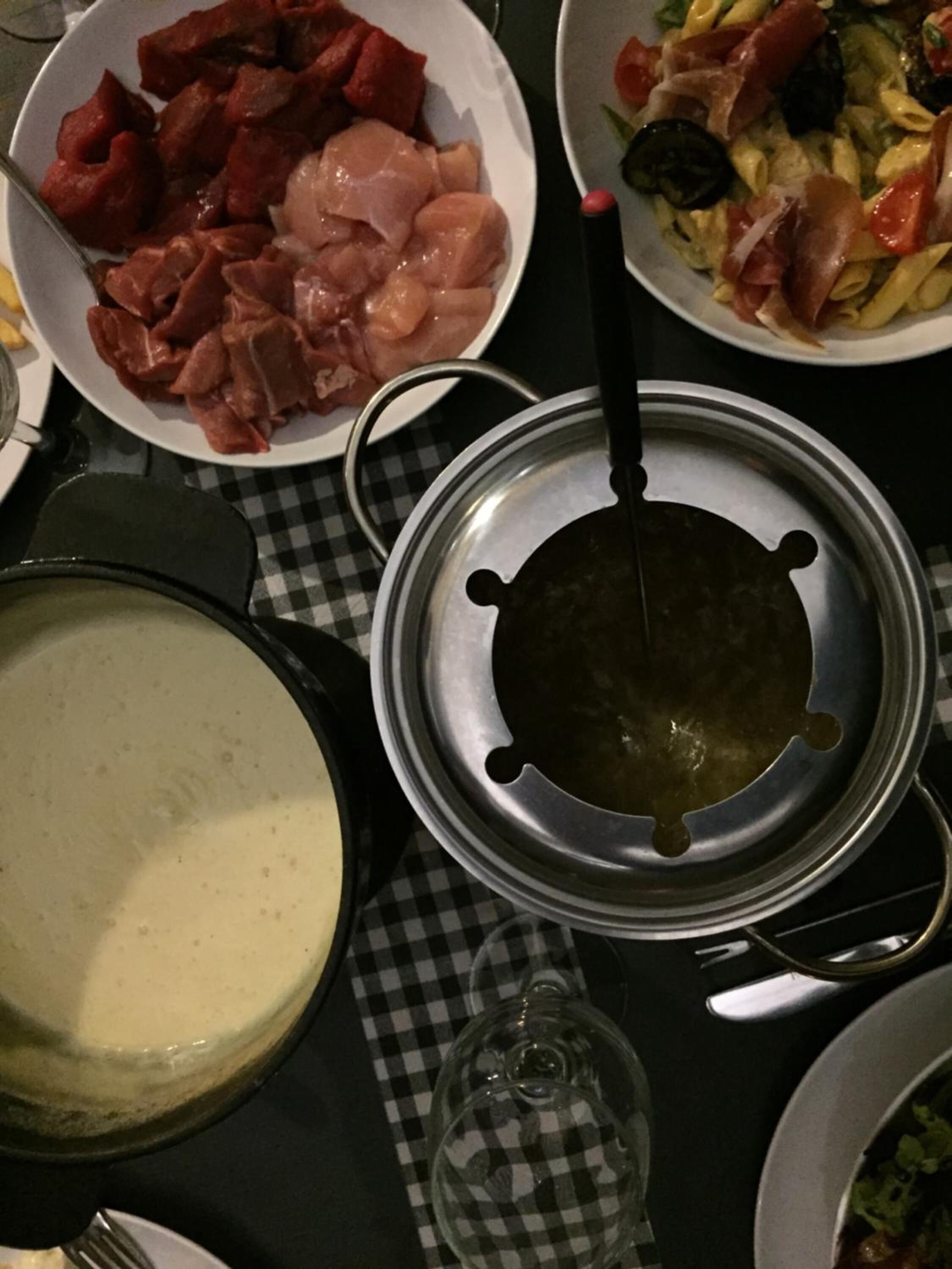 Ein Tisch mit verschiedenen Gerichten, darunter Fleisch, Pasta und einem Suppentopf.