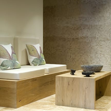 Una habitación moderna y minimalista con un banco de madera y una pequeña mesa de madera.