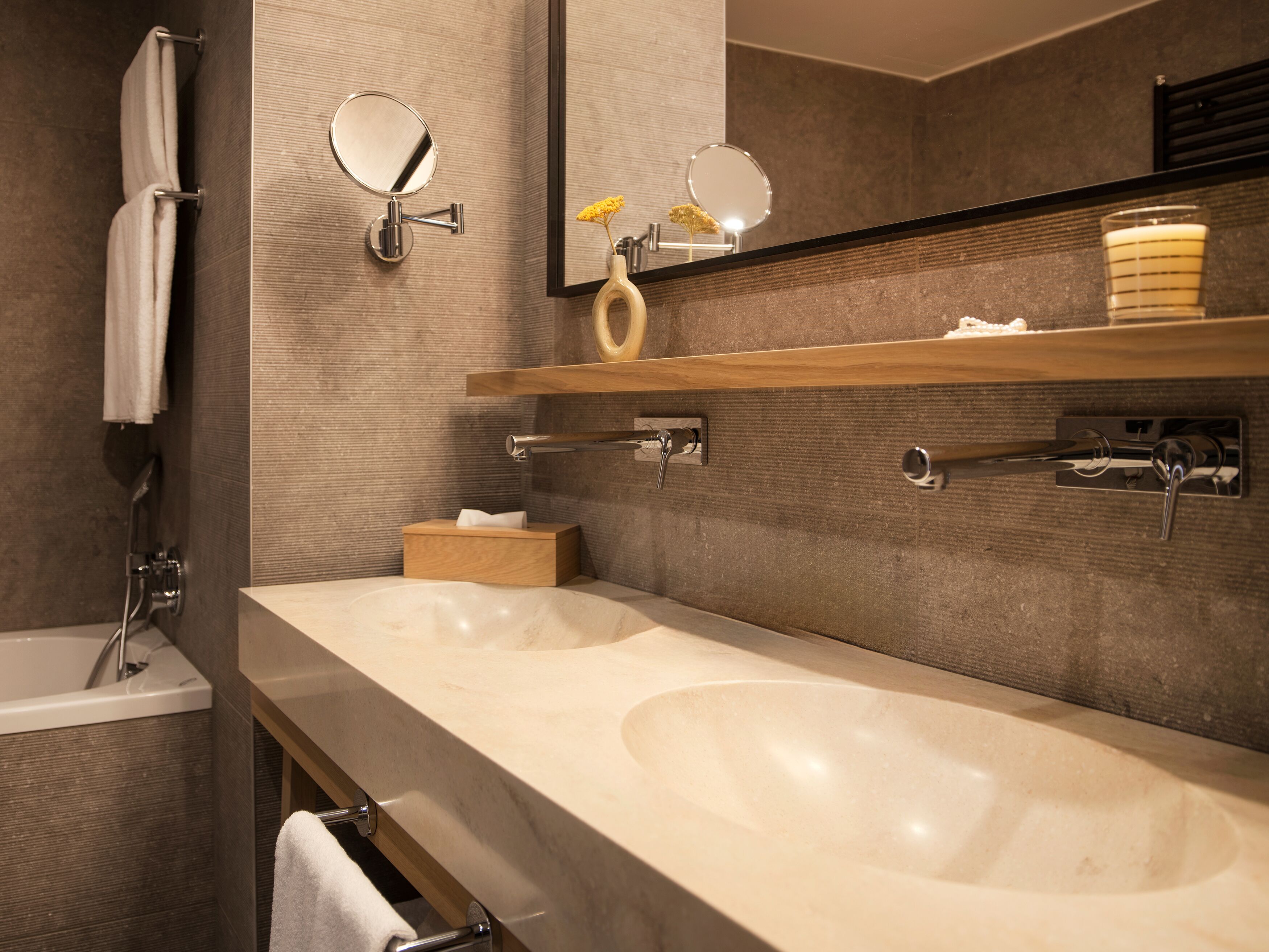Une salle de bain moderne avec deux lavabos, un miroir et un porte-serviettes.