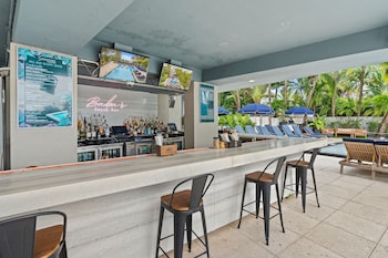 A modern lobby with a blue sofa, a reception desk, and a large abstract painting. at The Sagamore Hotel South Beach - An All Suite Hotel