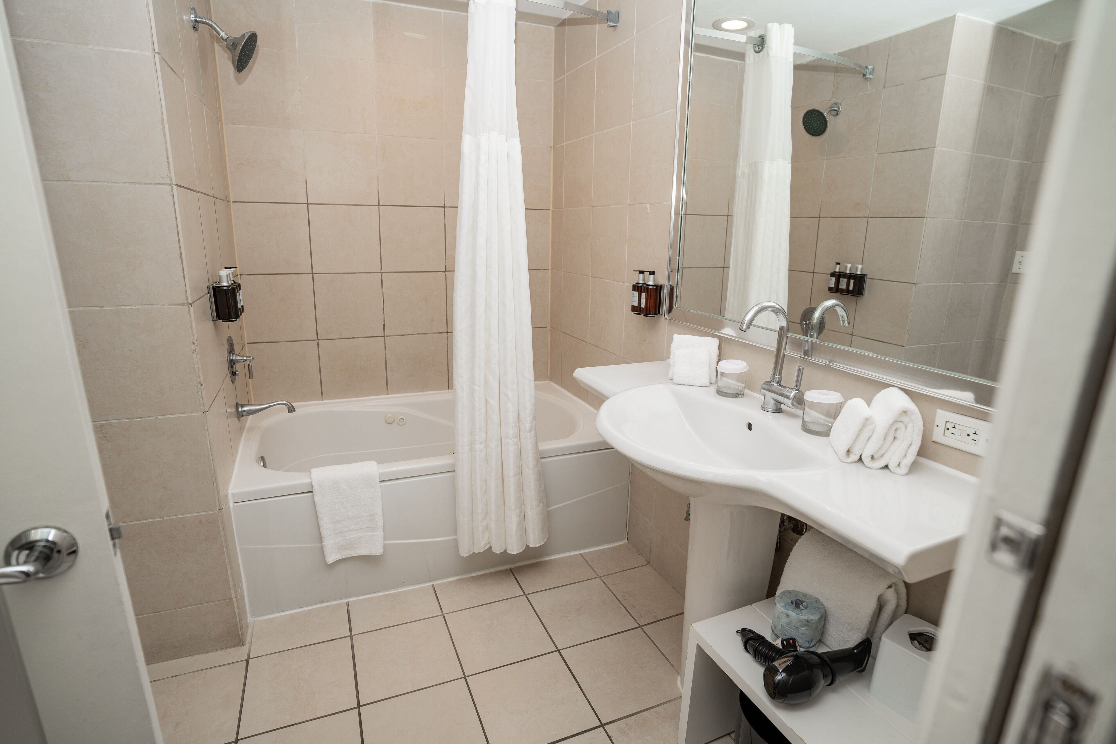 A modern bathroom with a bathtub, a sink, and a mirror.