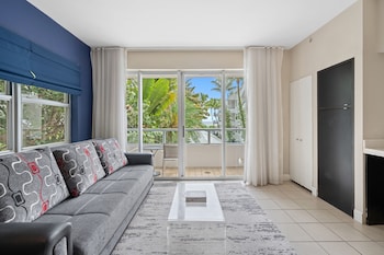 A modern kitchen with a built-in oven, a large window, and a spiral staircase. at The Sagamore Hotel South Beach - An All Suite Hotel