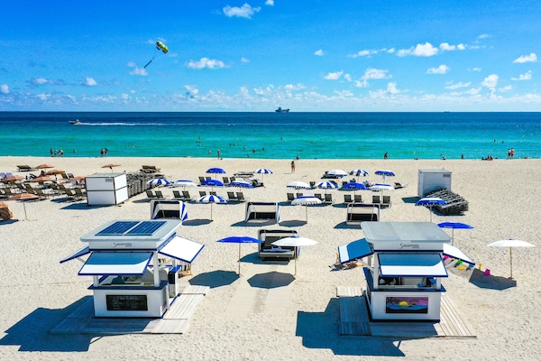 Plage, sable blanc, parasols, serviettes de plage