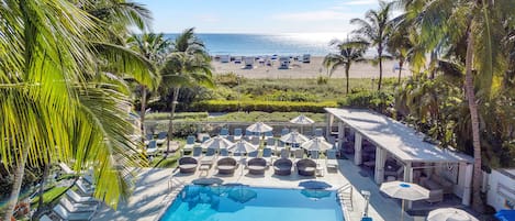 Alberca al aire libre, sombrillas en la alberca y camastros