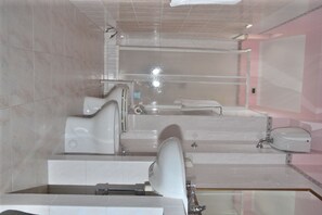 A modern bathroom with a bathtub, toilet, and sink. - Villaggio Hotel Eurolido (Falerna)