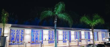 An outdoor dining area with modern seating and a well-lit reception area with decorative wall panels.