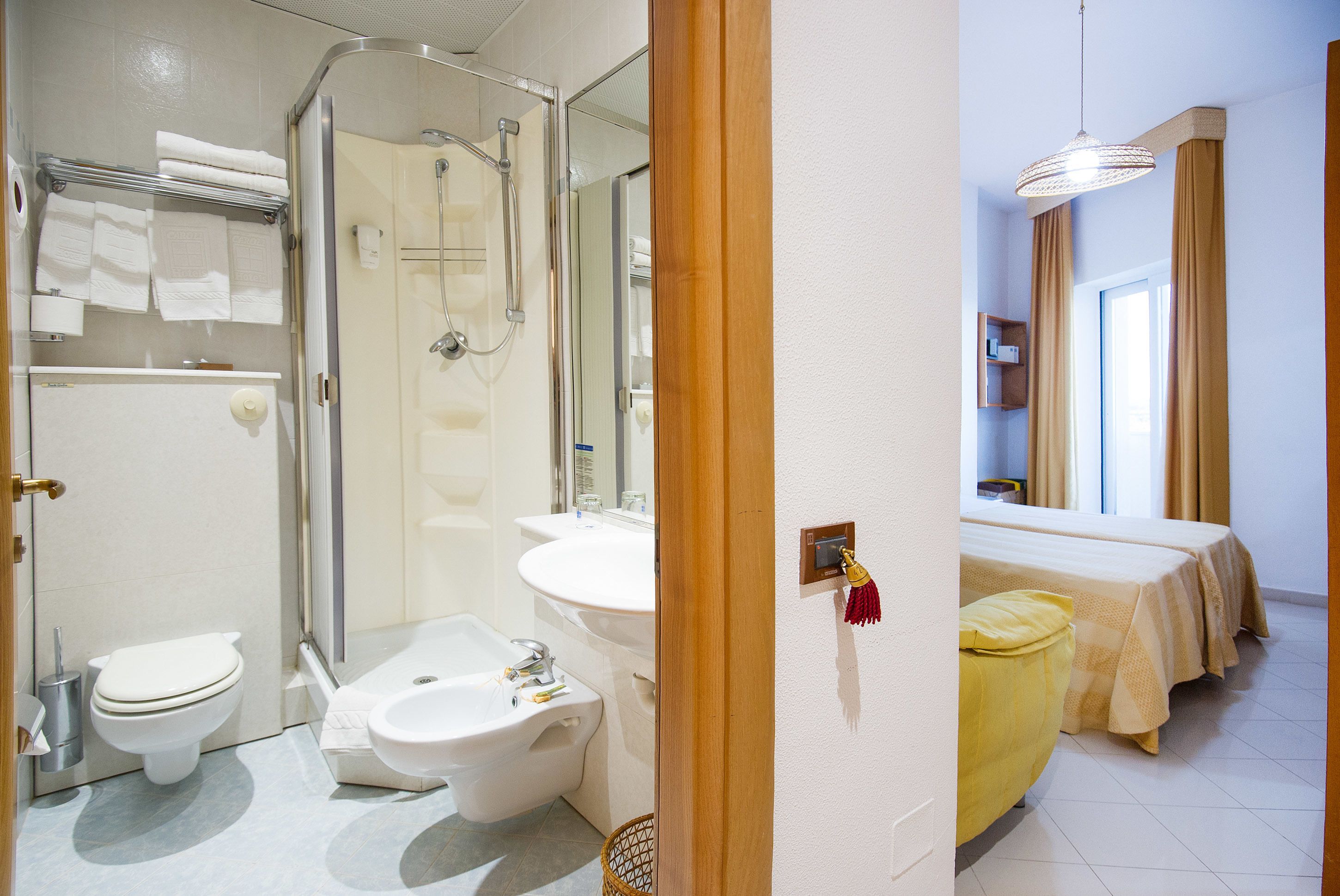 A modern bathroom with a shower, toilet, bidet, and sink.