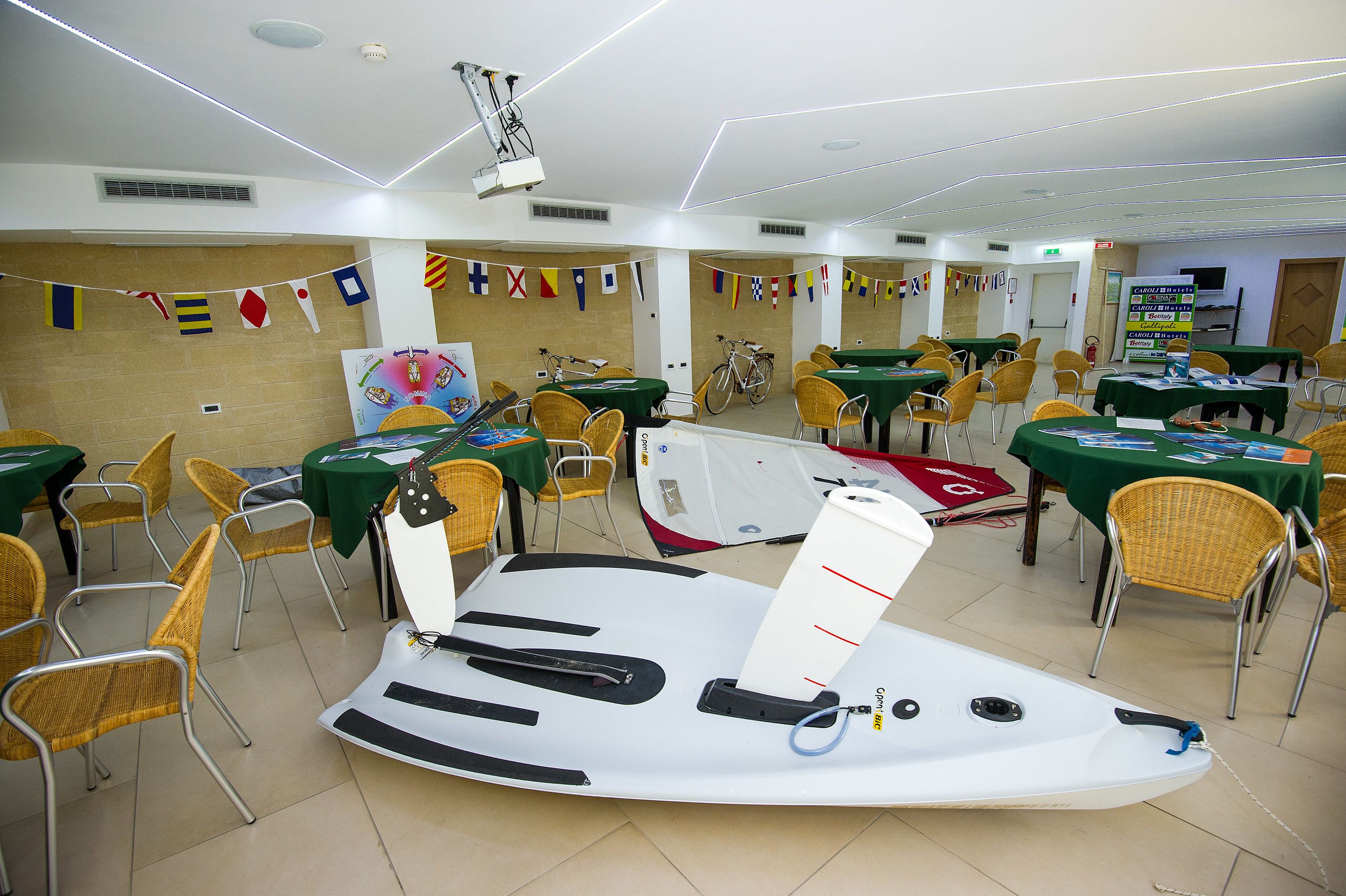 Una sala conferenze con tavoli, sedie e una tavola da surf.