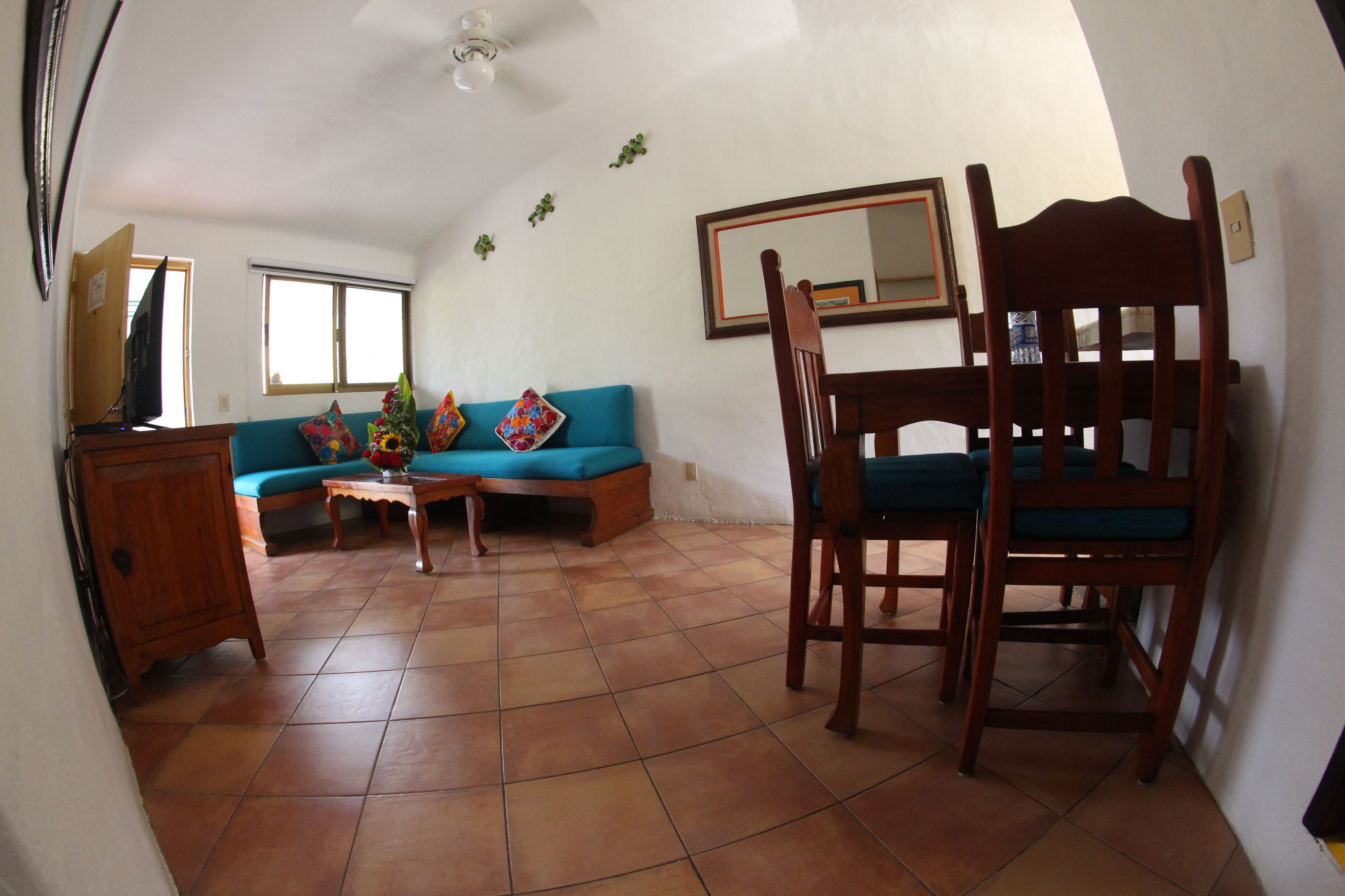 Ein Wohnzimmer mit einer Couch, einem Holzstuhl, einem Couchtisch und einem Fernseher.