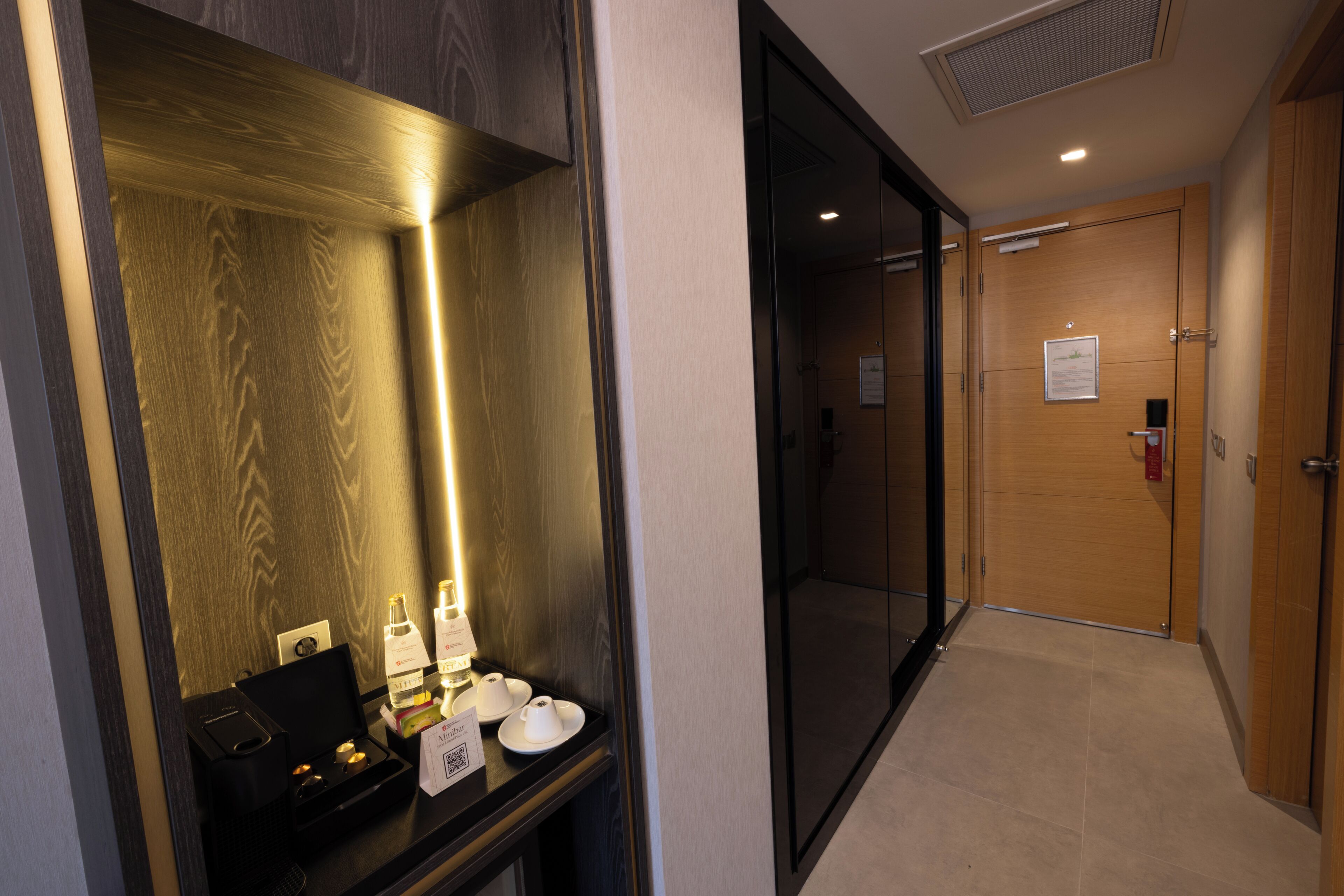 Pasillo de hotel con mostrador de recepción, un espejo y una puerta.