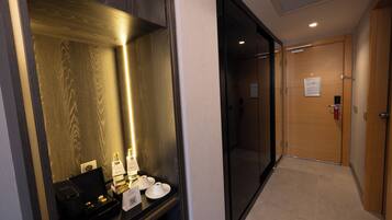 Pasillo de hotel con mostrador de recepción, un espejo y una puerta.
