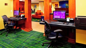 A hotel lobby with two computer workstations, a reception desk, and a seating area with a sofa and chairs. - Fairfield Inn & Suites by Marriott Phoenix Midtown (Phoenix)