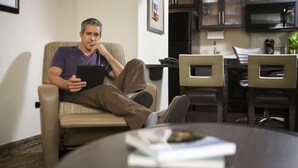 A man sitting on a reclining chair in a room with a dining area visible in the background. - Candlewood Suites Austin-Round Rock by IHG (Round Rock)