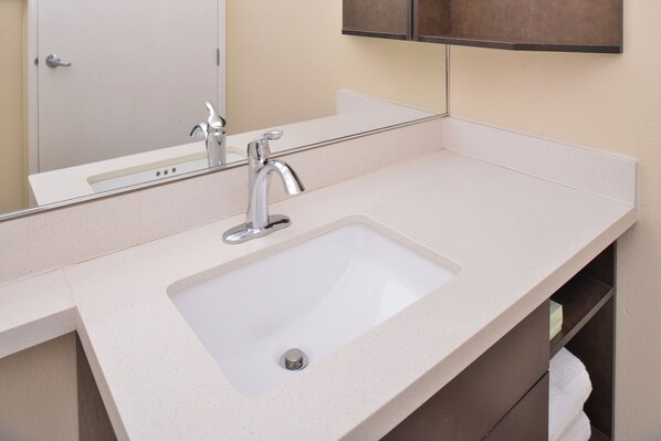 A bathroom with a white sink, a mirror, and a towel rack. - Candlewood Suites Austin-Round Rock by IHG (Round Rock)