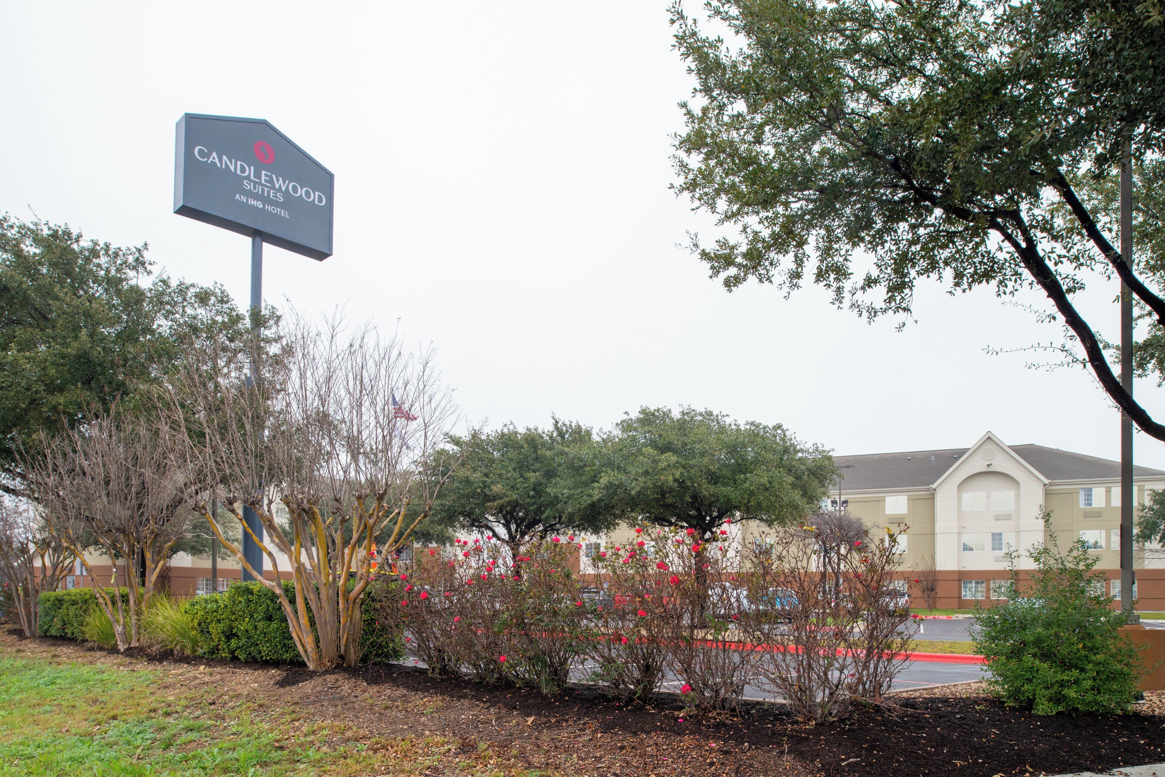 A hotel sign with a logo and text indicating it is a Candlewood Suites hotel.