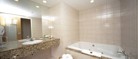 A bathroom with two sinks, a bathtub, and a large mirror.