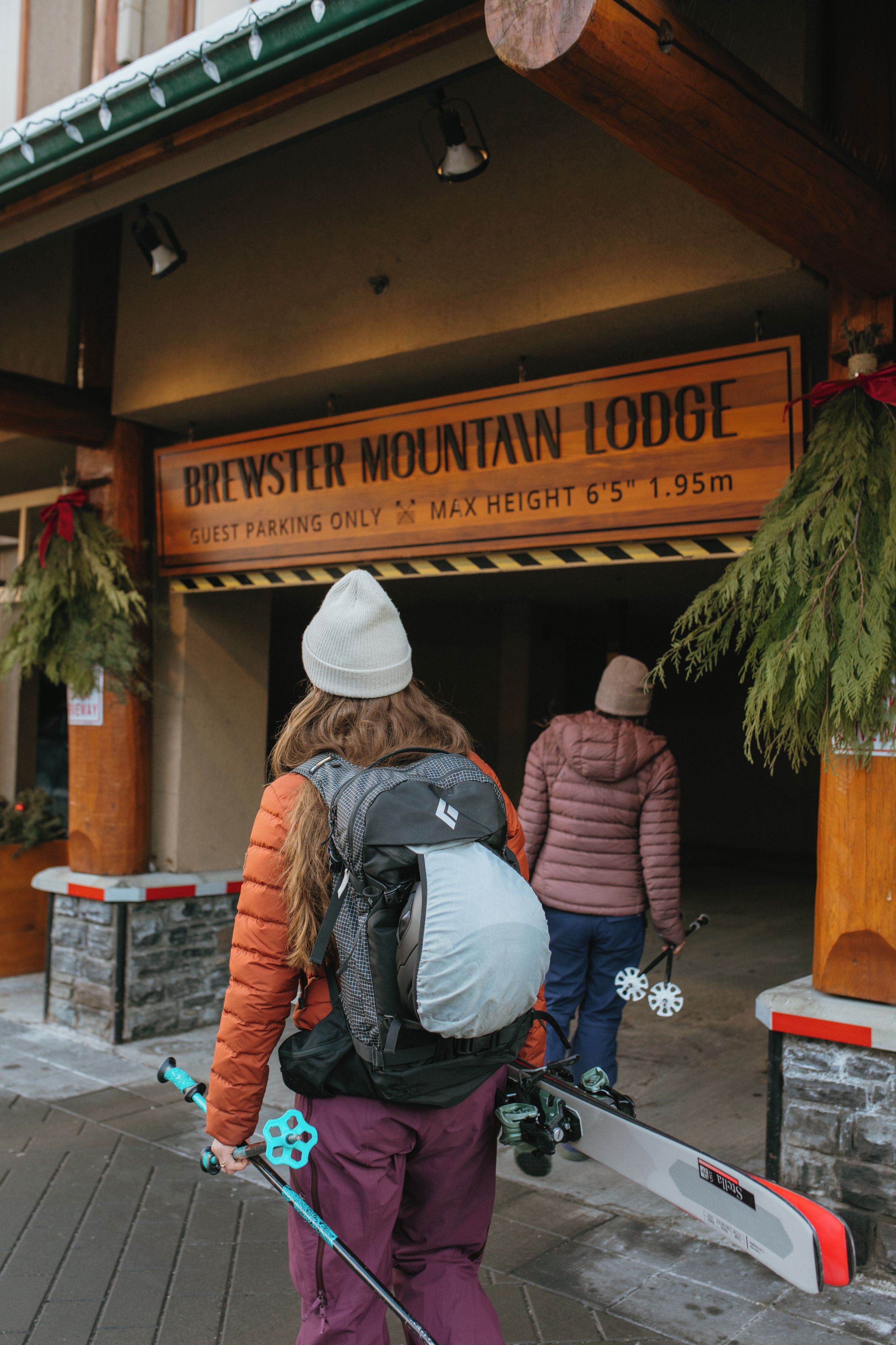 A sign for Brewster Mountain Lodge indicating guest parking only and a maximum height of 6'5'.