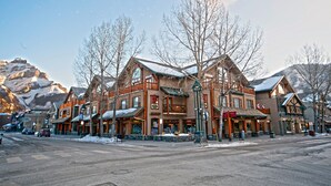A multi-story building with a traditional architectural style, featuring large windows and a prominent entrance. - Brewster Mountain Lodge (Banff)