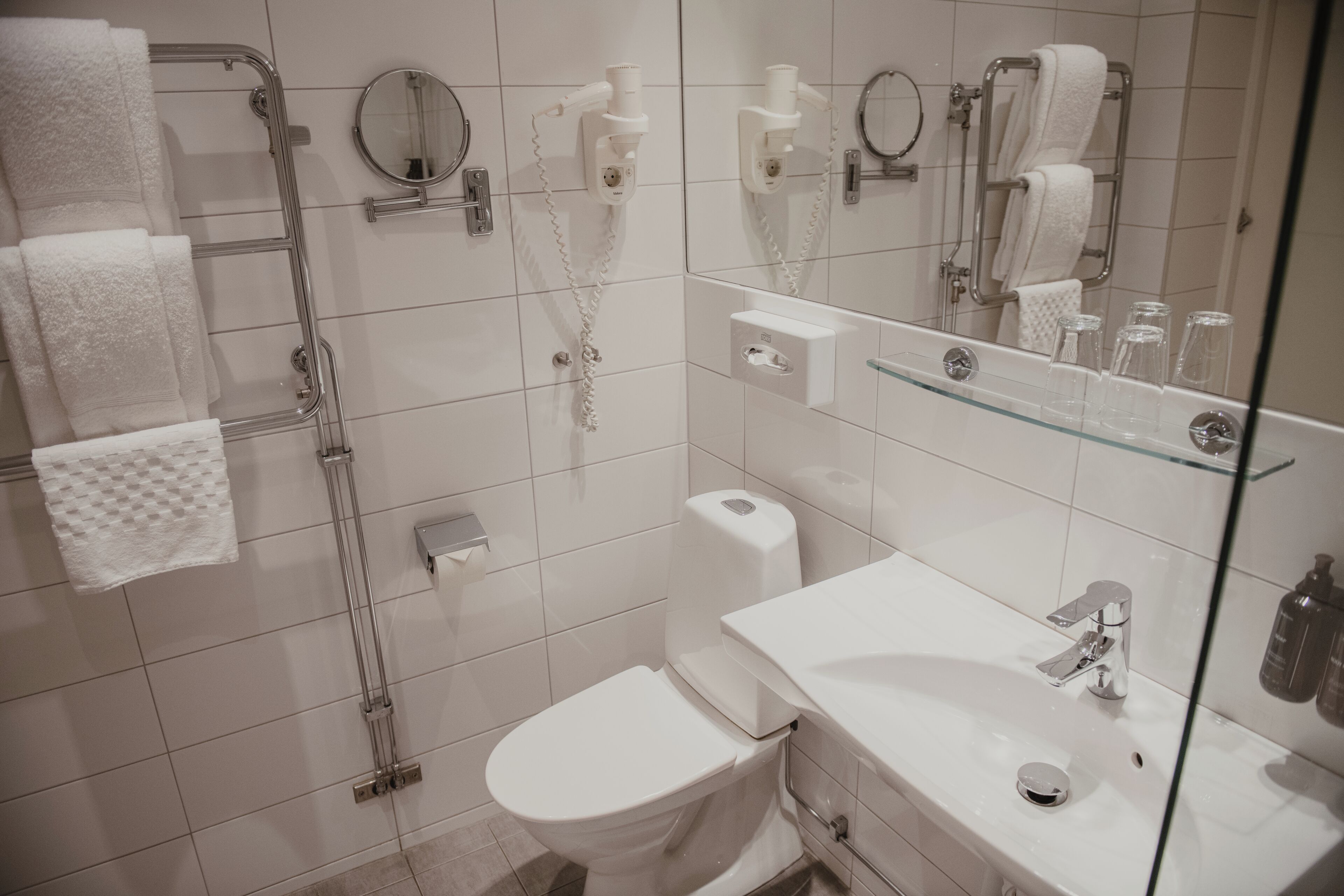 Een moderne badkamer met toilet, wastafel en douchecabine van glas.