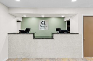 A reception desk with a sign that reads 'Quality INN BY CHOICE HOTELS'. - Quality Inn Ghent (Ghent)