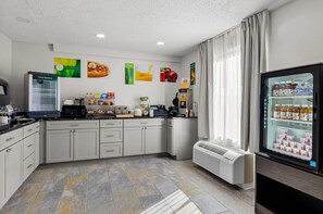 A modern kitchen with a refrigerator, microwave, and coffee maker. - Quality Inn Ghent (Ghent)
