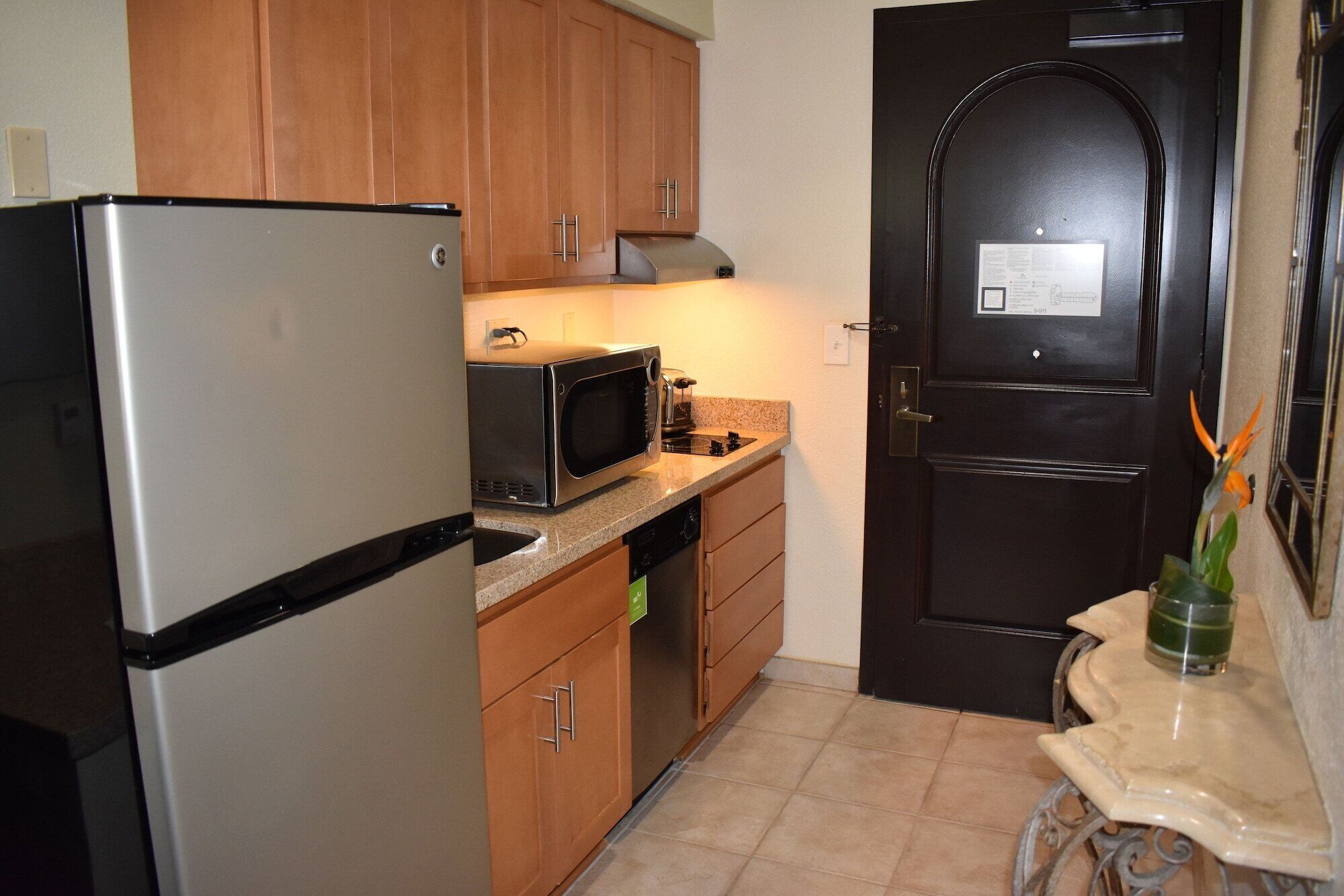 A compact kitchen with a refrigerator, microwave, and stove.