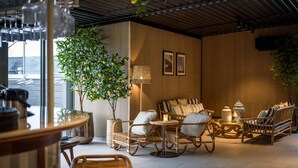 A cozy seating area with wicker furniture, a potted tree, and a lamp. - Quality Hotel Tonsberg (Tønsberg)