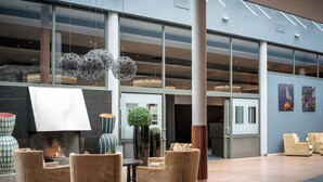 A modern lobby with a fireplace, seating area, and large windows. - Quality Hotel Tonsberg (Tønsberg)