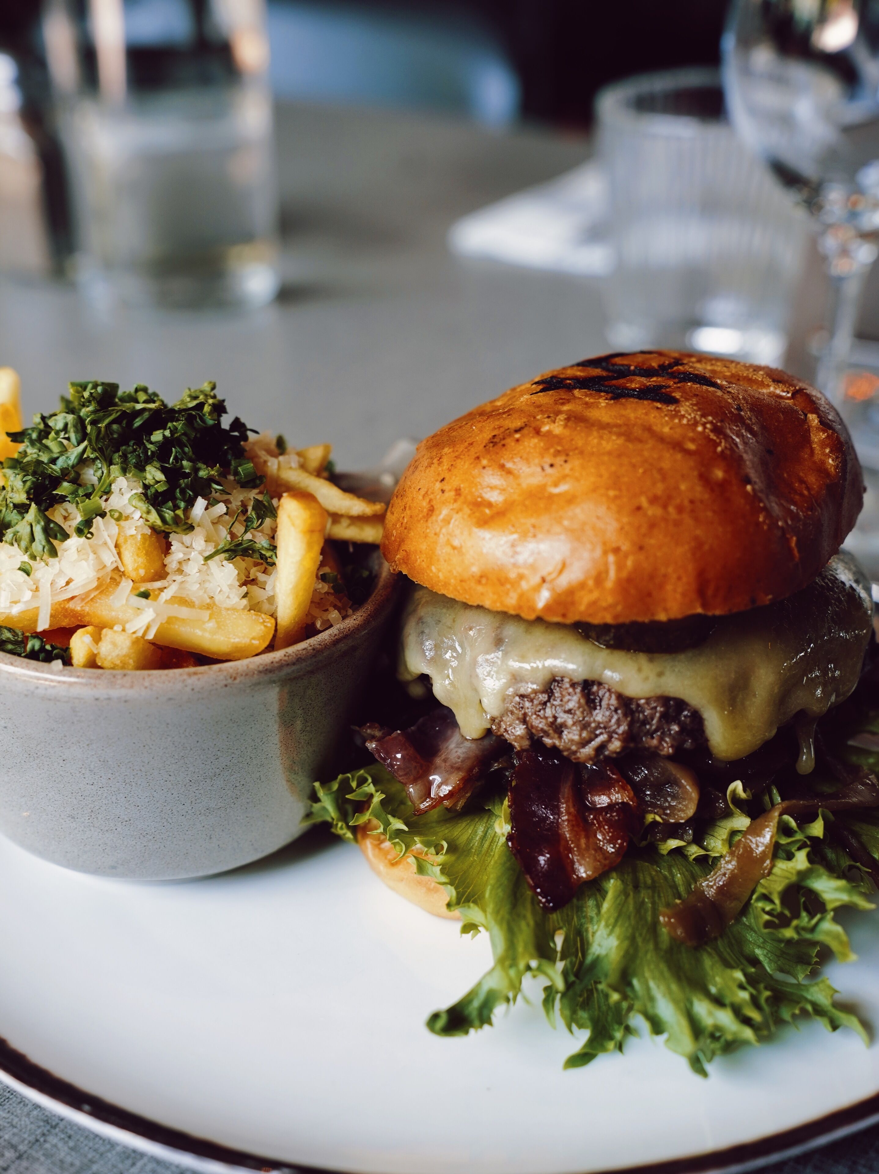 A plate with a burger and a bowl of pasta.