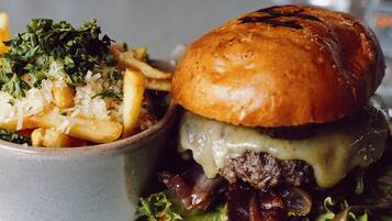 A plate with a burger and a bowl of pasta.