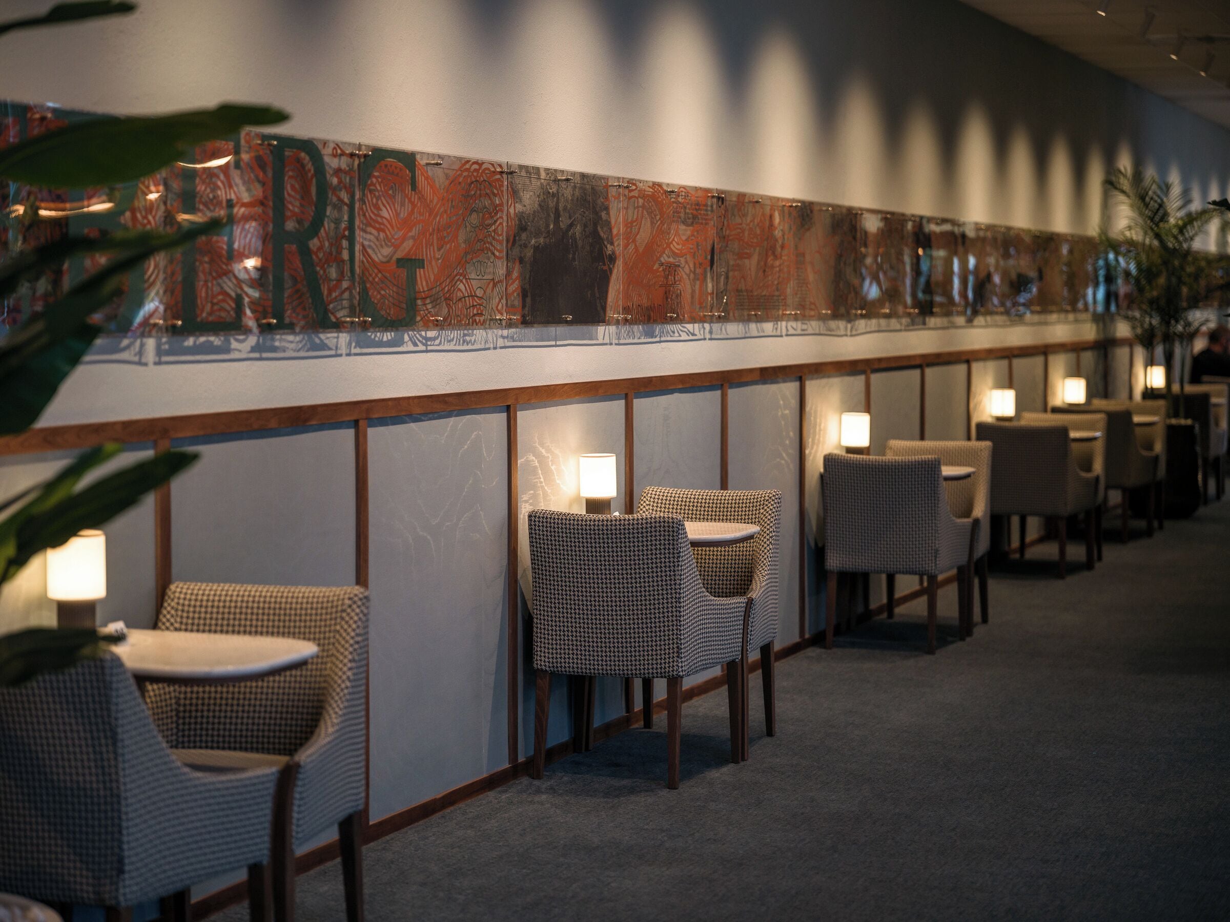 Un bar de hotel con una barra larga, sillas de mimbre y mesas.