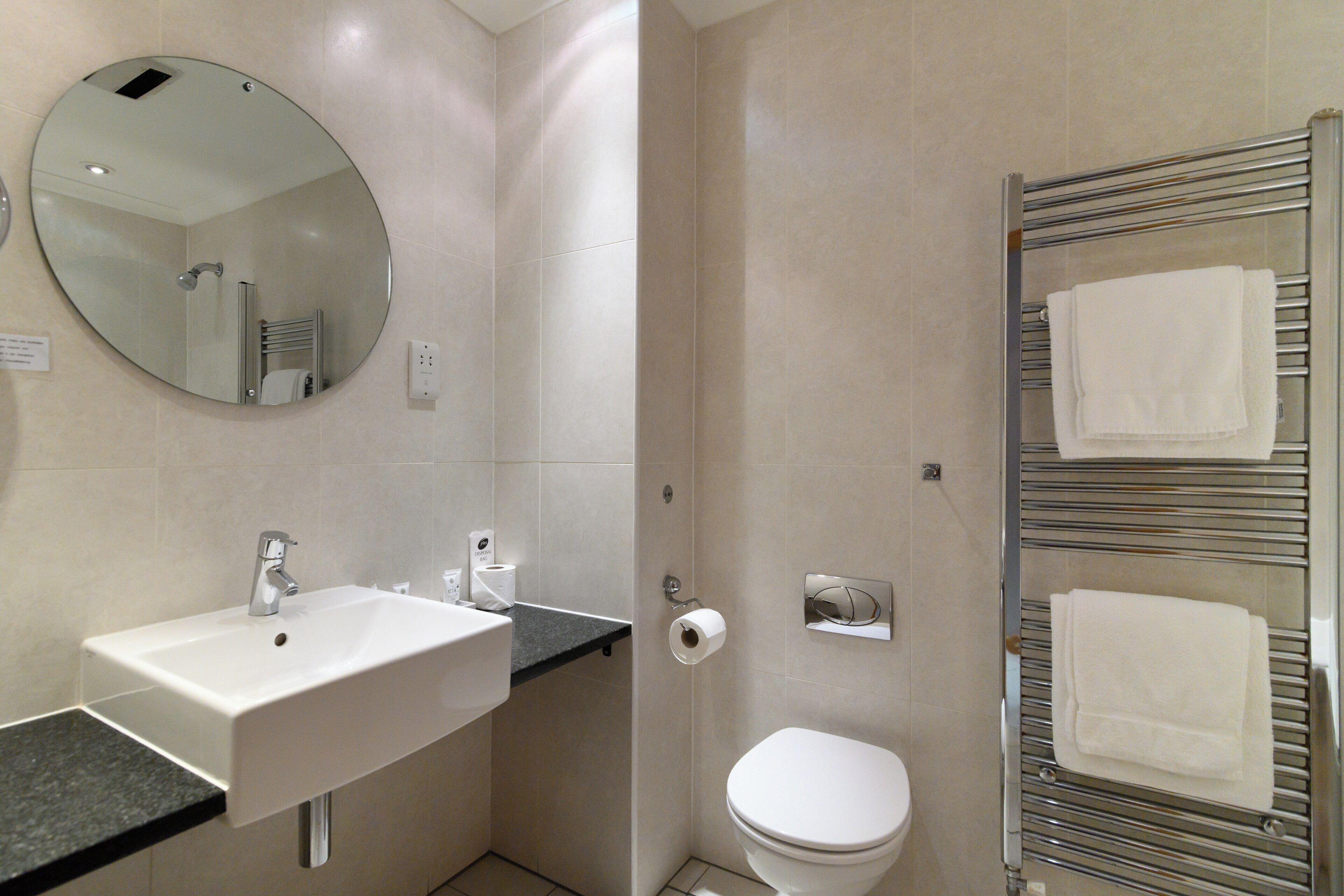 Une salle de bain équip ée d’un lavabo, de toilettes et d’un porte-serviettes.