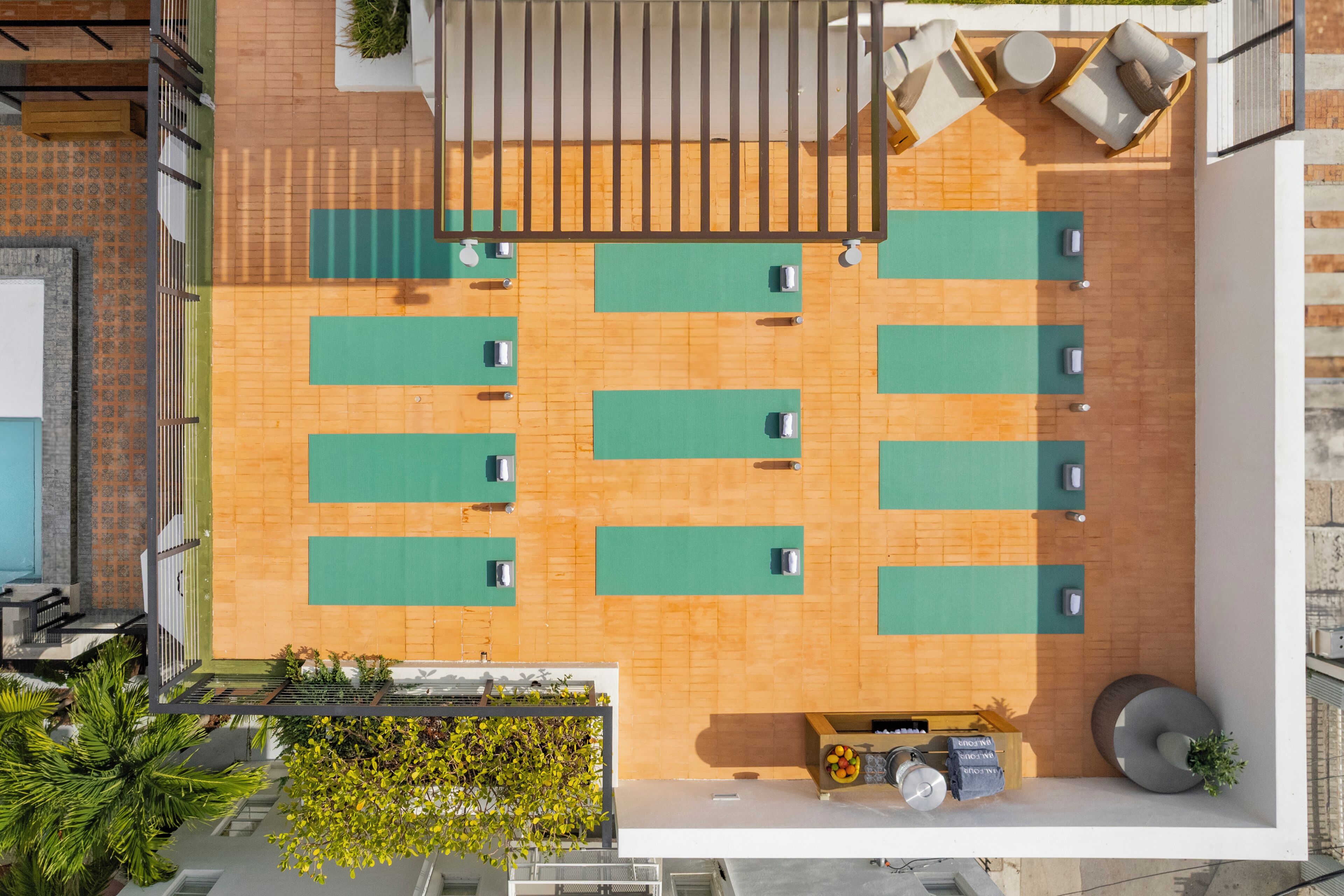 Una terraza en la azotea con varias zonas de estar, piscina y bar.