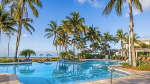 A swimming pool surrounded by palm trees and lounge chairs, with a clear view of the ocean in the background. - Hyatt Vacation Club at Windward Pointe, Key West (Key West)