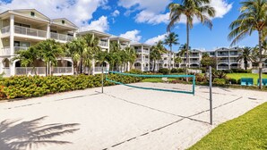 A beach volleyball court with a net, surrounded by palm trees and a hotel in the background. - Hyatt Vacation Club at Windward Pointe, Key West (Key West)