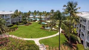 A resort with a well-maintained lawn, palm trees, a pool area, and a view of the ocean. - Hyatt Vacation Club at Windward Pointe, Key West (Key West)