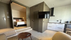 A compact living space with a kitchenette, a bed, and a TV. - Senator Barcelona Apartments (Barcelona)