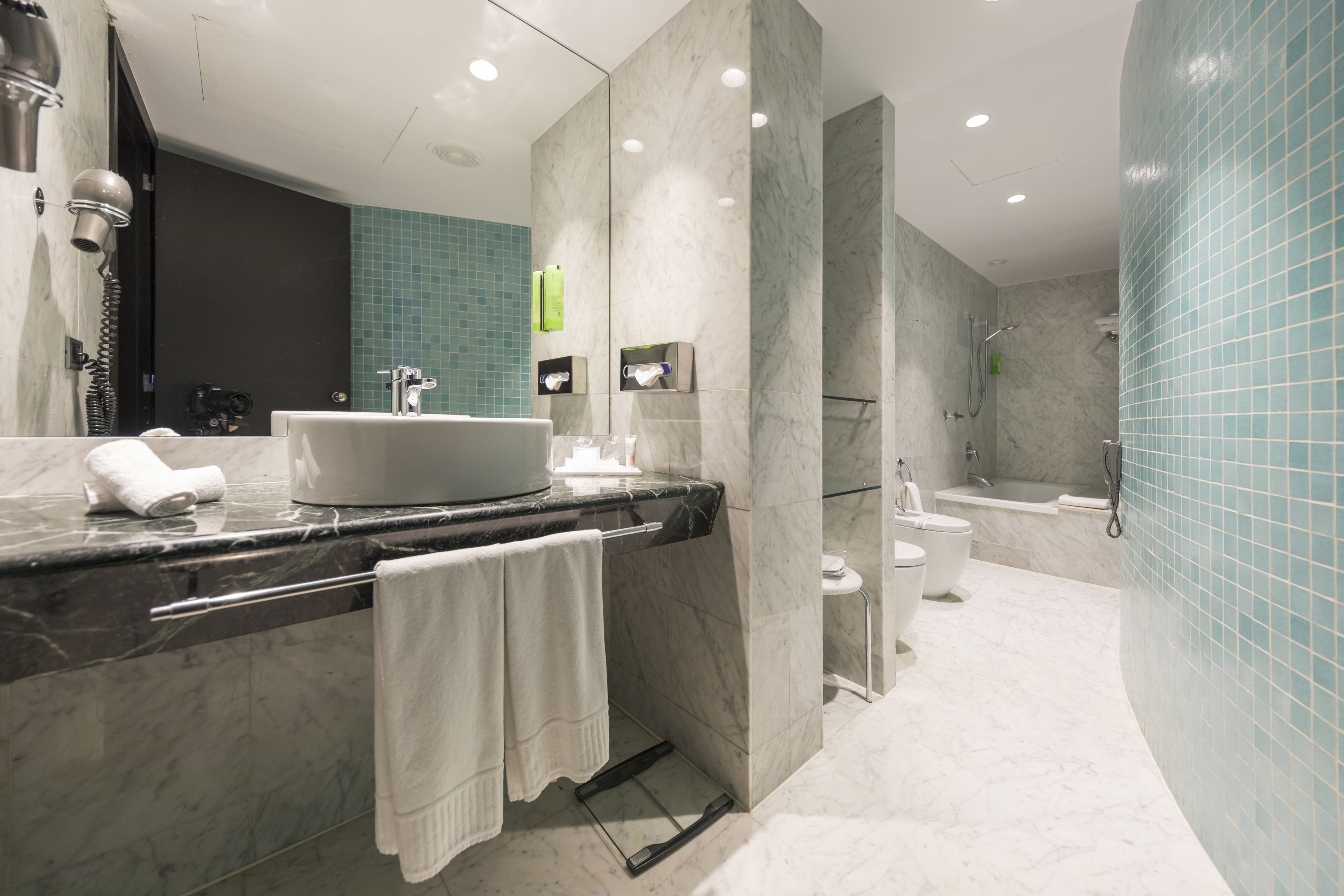 bathtub, designer toiletries, hair dryer, slippers