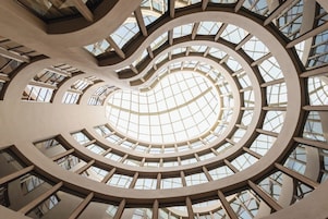 A spiral atrium with a glass ceiling and multiple levels of balconies.
