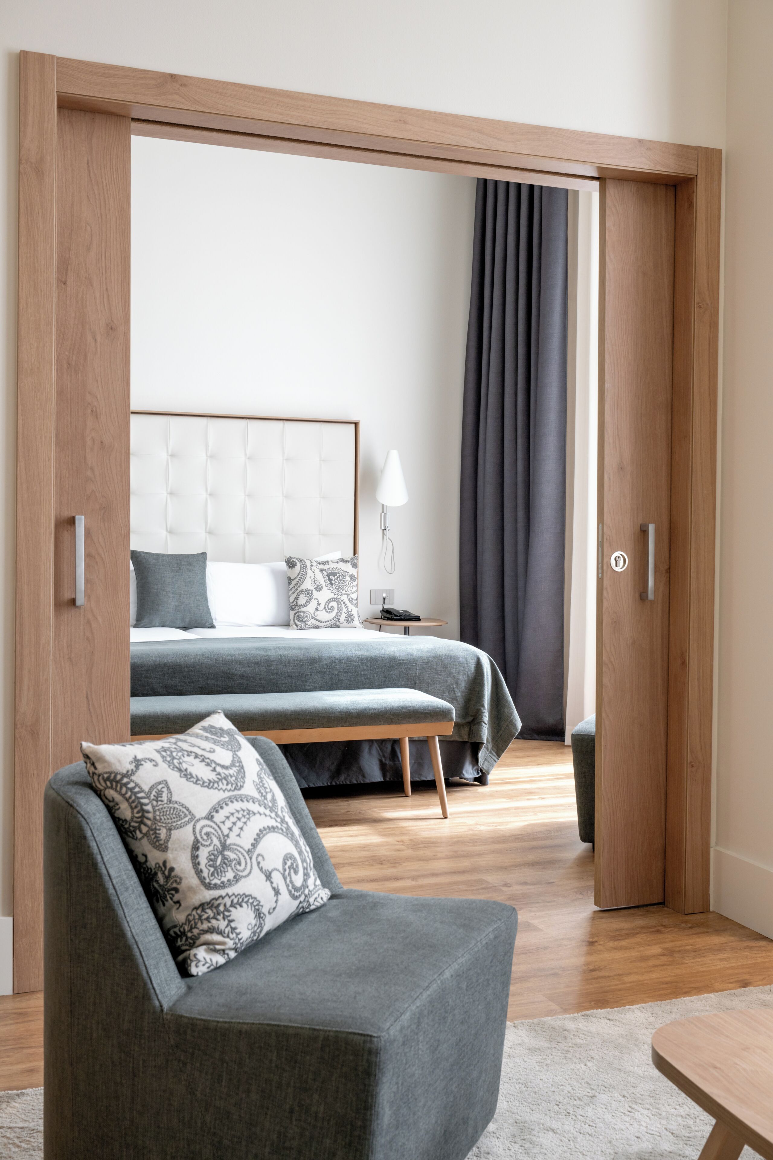 A modern bedroom with a bed, bedside table, and a chair.