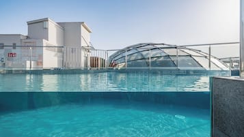 Una piscina al aire libre, tumbonas
