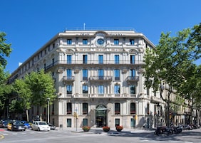 A historic building with a clock tower, multiple balconies, and a grand entrance.