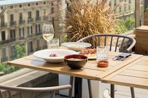 A dining table with plates, bowls, glasses, and cutlery.