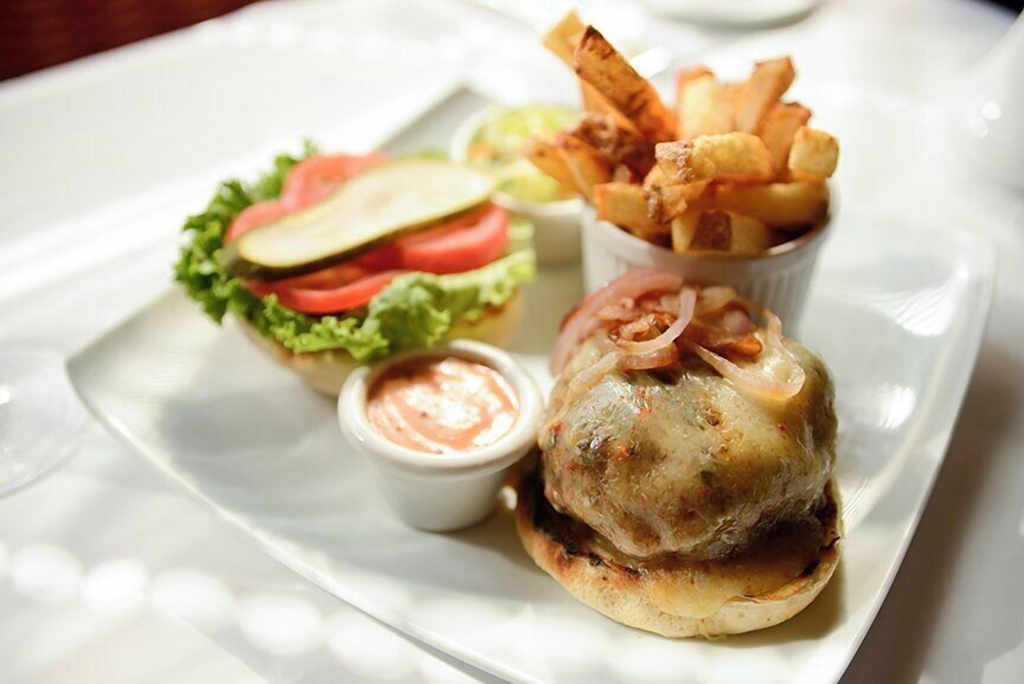 Une assiette avec un hamburger, des frites et une salade d’accompagnement.